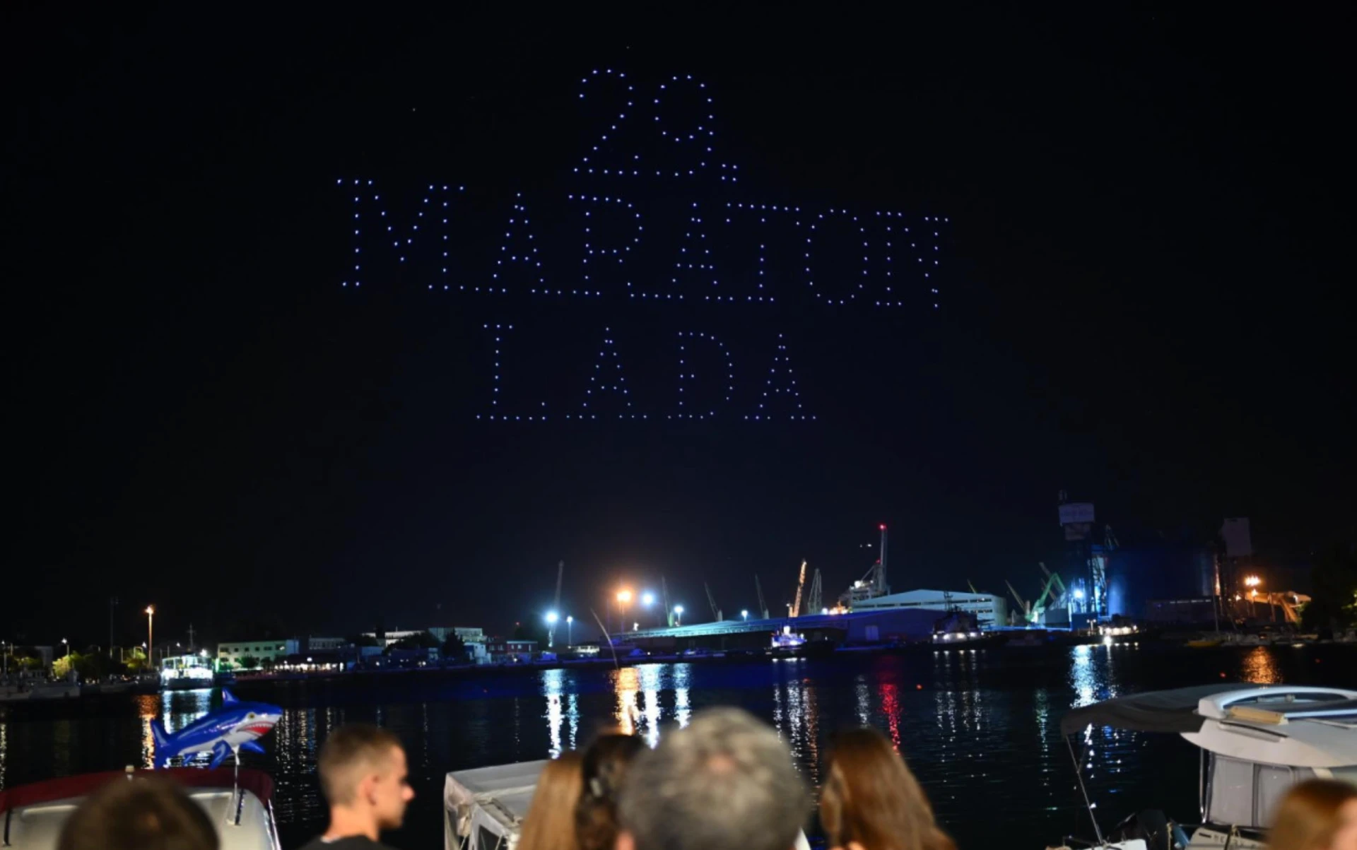 Drones spelling '29. MARATON LAĐA' above a night harbour