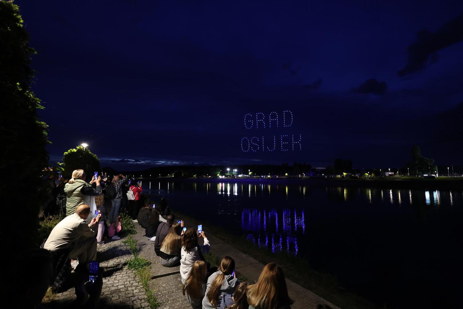 Drones spelling 'GRAD OSIJEK' above a riverside crowd