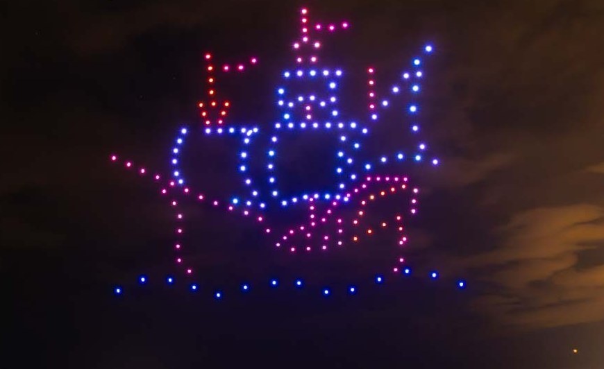 Historic sailing ship drawn in drone lights above the sea