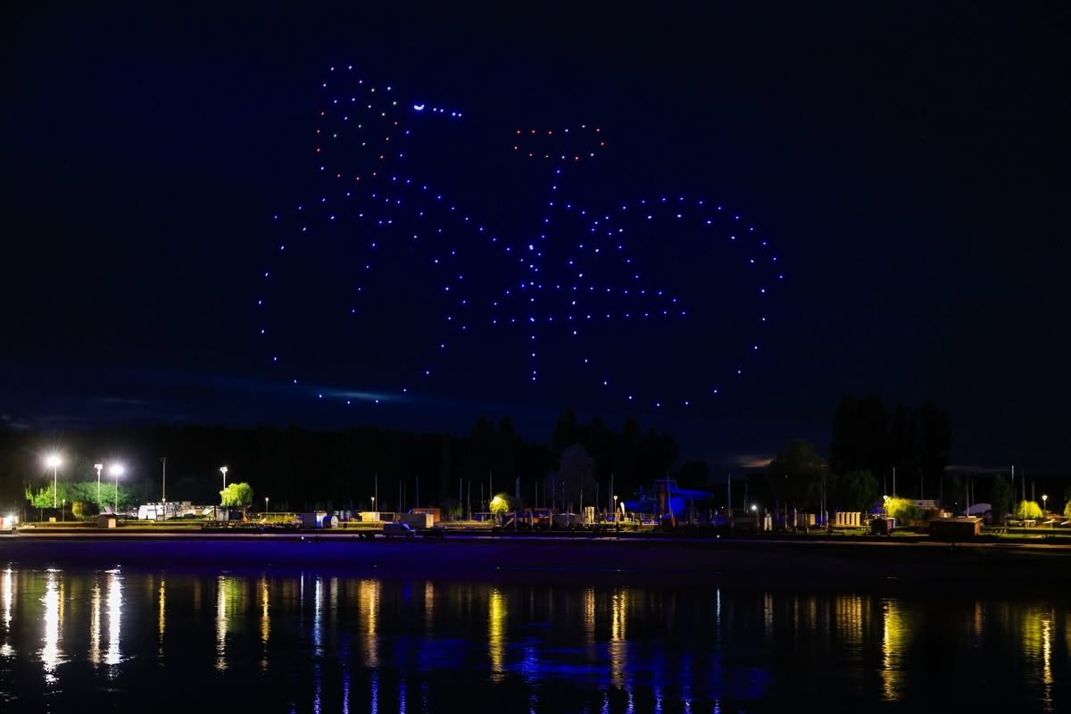 Large drone-formed bicycle glowing over the waterfront